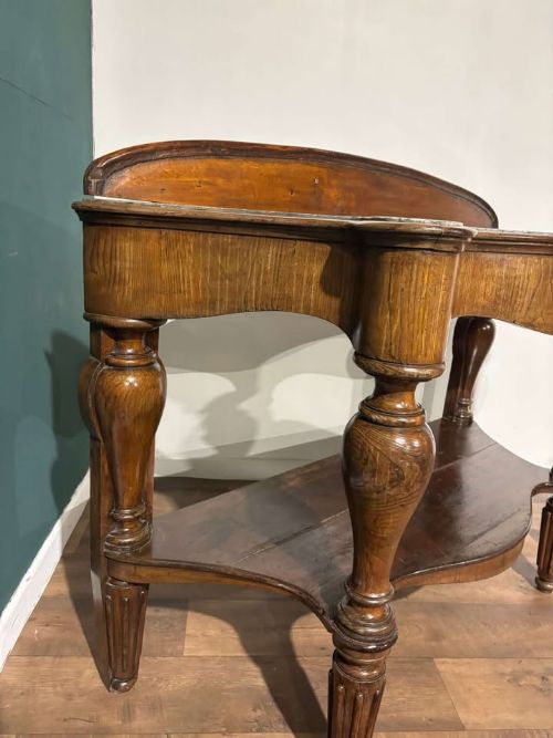 fig 3. A Victorian mahogany console table featuring a serpentine-contoured top, low splashback, turned and fluted legs, and a matching lower tier shelf.