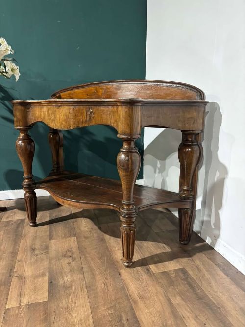 fig 5. A Victorian mahogany console table featuring a serpentine-contoured top, low splashback, turned and fluted legs, and a matching lower tier shelf.
