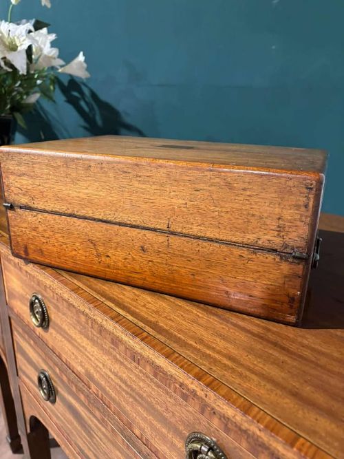 fig 3. A rectangular Victorian mahogany writing slope featuring brass side carrying handles and a brass keyhole escutcheon.