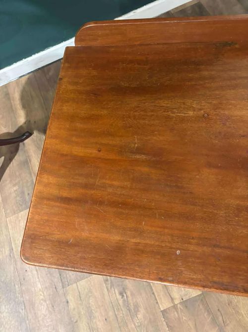 fig 1. A Victorian mahogany washstand featuring two drawers with wooden knob handles, a low gallery back, turned legs, and brass castors.