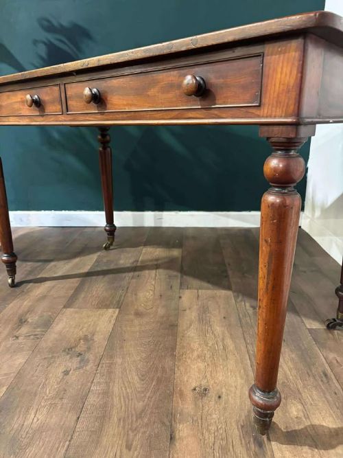fig 6. A Victorian mahogany washstand featuring two drawers with wooden knob handles, a low gallery back, turned legs, and brass castors.