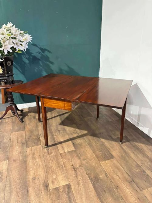 fig 1. A Victorian mahogany drop-leaf gateleg table with two extended leaves, straight legs, and small brass castors.