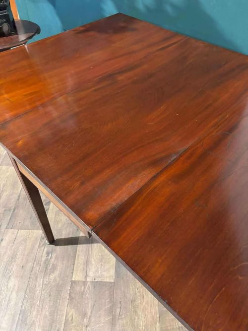 fig 6. A Victorian mahogany drop-leaf gateleg table with two extended leaves, straight legs, and small brass castors.