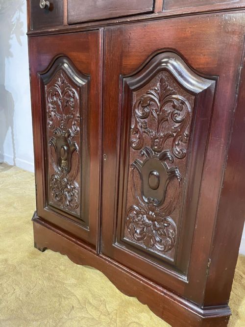 fig 6. A tall, dark mahogany late 19th-century corner cupboard featuring a glazed upper display cabinet, an open central gallery, and carved lower panel doors.