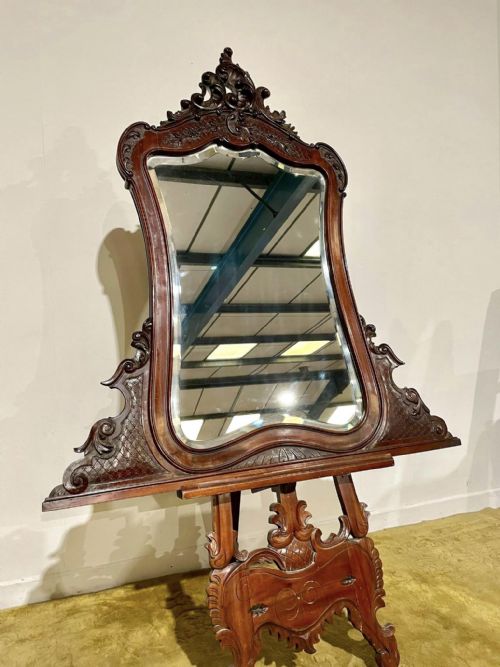 fig 1. A Victorian carved mahogany frame featuring ornate cresting scrollwork, cross-hatch detailing, and a shaped bevelled glass mirror plate.