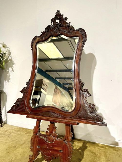 fig 2. A Victorian carved mahogany frame featuring ornate cresting scrollwork, cross-hatch detailing, and a shaped bevelled glass mirror plate.