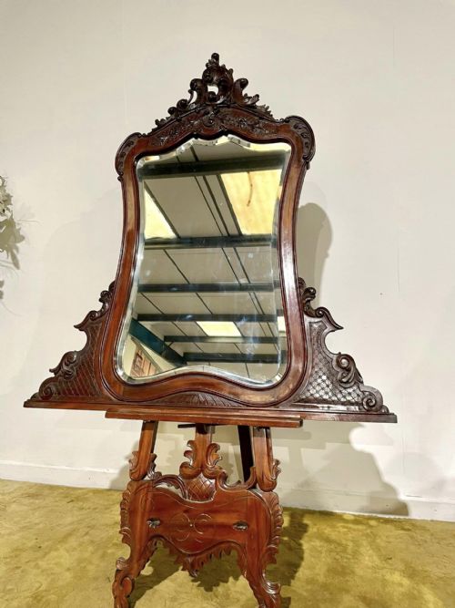 fig 3. A Victorian carved mahogany frame featuring ornate cresting scrollwork, cross-hatch detailing, and a shaped bevelled glass mirror plate.