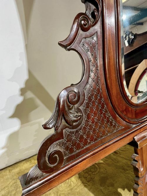 fig 4. A Victorian carved mahogany frame featuring ornate cresting scrollwork, cross-hatch detailing, and a shaped bevelled glass mirror plate.