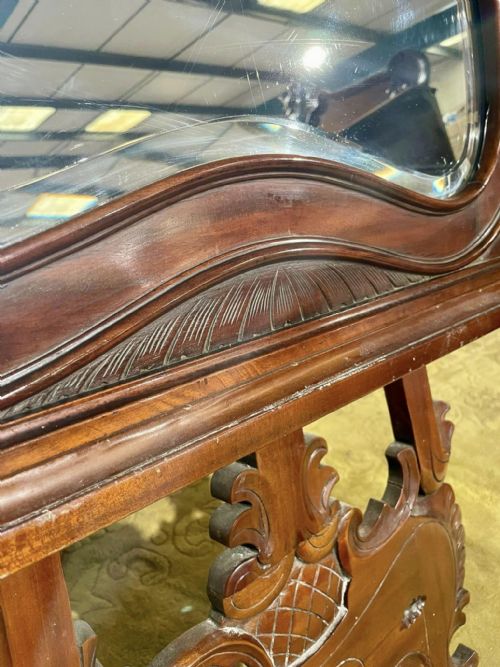 fig 6. A Victorian carved mahogany frame featuring ornate cresting scrollwork, cross-hatch detailing, and a shaped bevelled glass mirror plate.