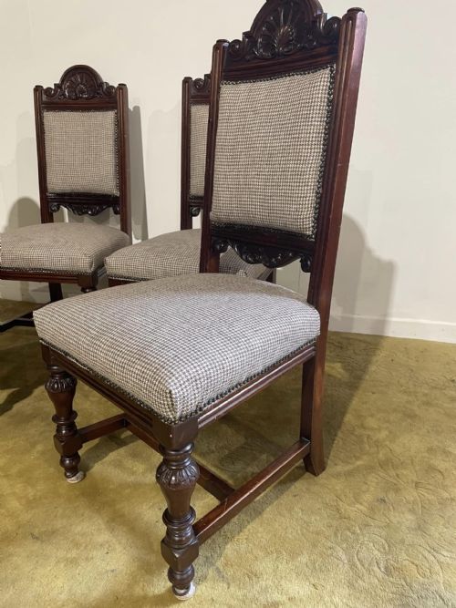 fig 2. A set of four dark timber Victorian dining chairs featuring carved shell crests, turned front legs, and patterned houndstooth fabric upholstery.