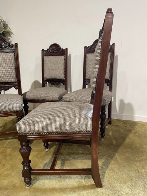 fig 6. A set of four dark timber Victorian dining chairs featuring carved shell crests, turned front legs, and patterned houndstooth fabric upholstery.