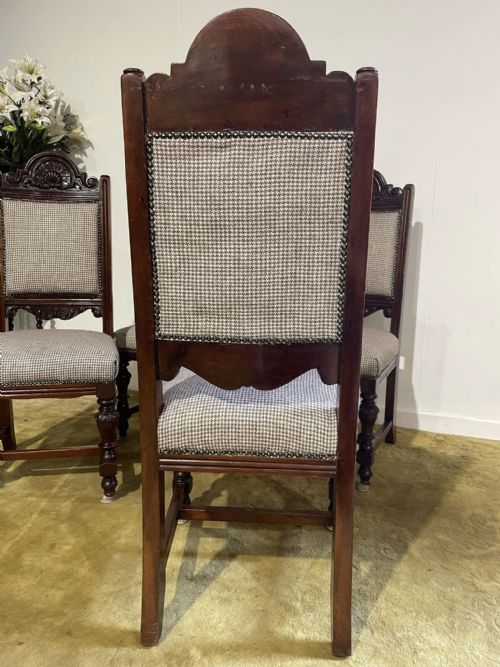 fig 7. A set of four dark timber Victorian dining chairs featuring carved shell crests, turned front legs, and patterned houndstooth fabric upholstery.