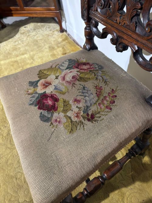 fig 2. A Carolean carved oak high back side chair featuring an intricately carved foliage cresting, turned supports, and a floral needlepoint seat.
