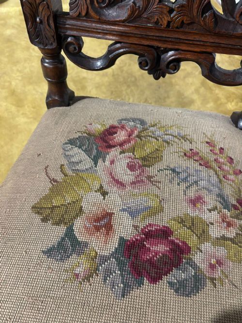 fig 3. A Carolean carved oak high back side chair featuring an intricately carved foliage cresting, turned supports, and a floral needlepoint seat.