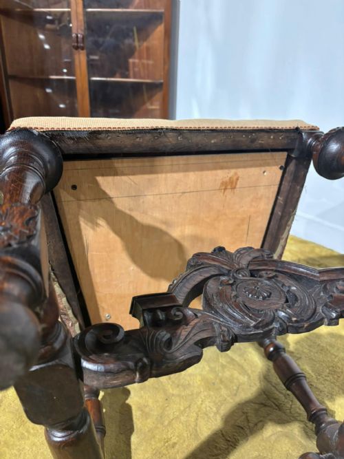 fig 4. A Carolean carved oak high back side chair featuring an intricately carved foliage cresting, turned supports, and a floral needlepoint seat.