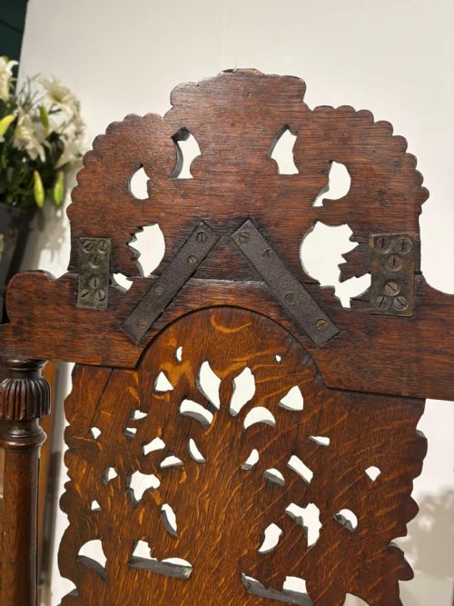 fig 5. A Carolean carved oak high back side chair featuring an intricately carved foliage cresting, turned supports, and a floral needlepoint seat.