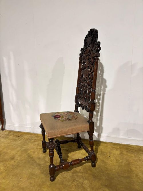 fig 8. A Carolean carved oak high back side chair featuring an intricately carved foliage cresting, turned supports, and a floral needlepoint seat.