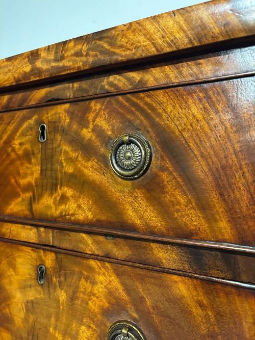 fig 4. A tall Victorian flame mahogany cabinet featuring two upper drawers with brass ring handles above a single panelled cupboard door on a plinth base.