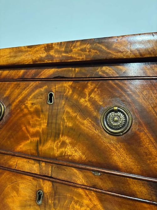 fig 6. A tall Victorian flame mahogany cabinet featuring two upper drawers with brass ring handles above a single panelled cupboard door on a plinth base.