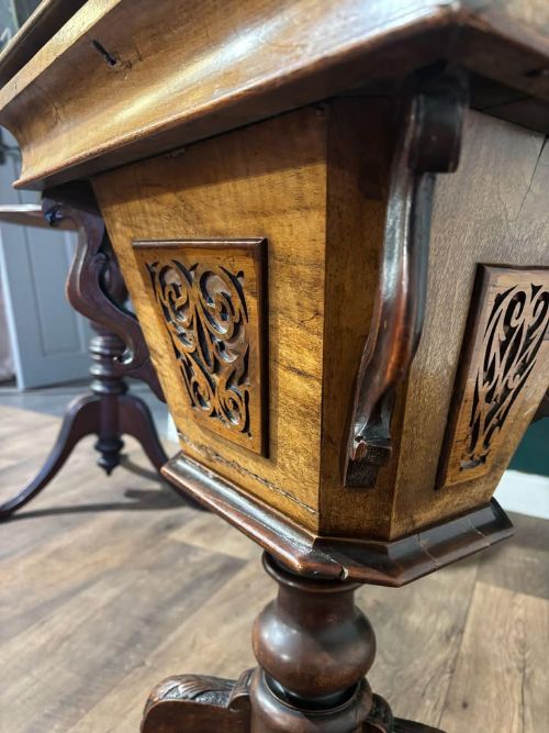 fig 4. A 19th-century Victorian walnut trumpet sewing table with fretwork side panels, a hinged top lid, turned pedestal, and carved tripod cabriole legs.