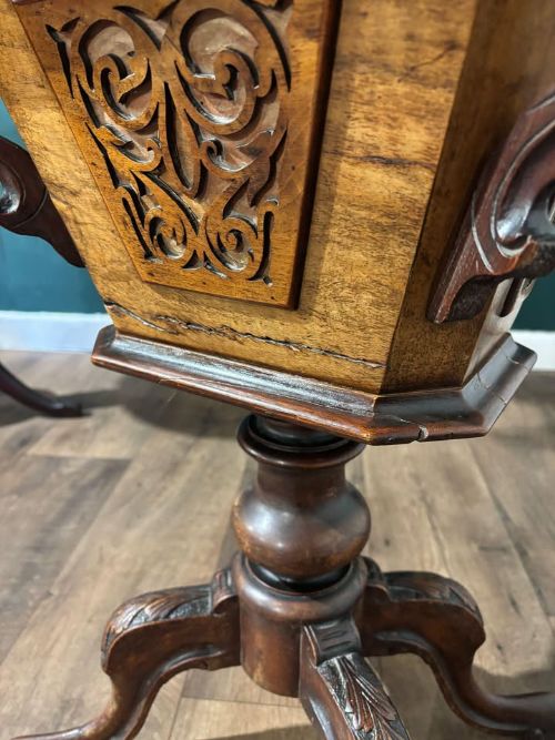fig 6. A 19th-century Victorian walnut trumpet sewing table with fretwork side panels, a hinged top lid, turned pedestal, and carved tripod cabriole legs.