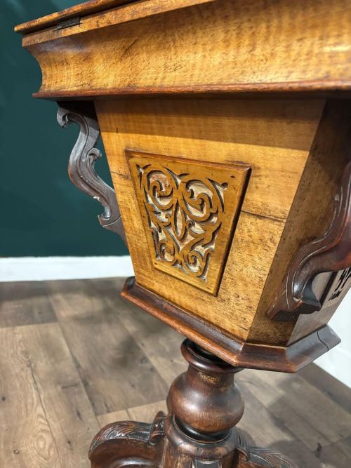fig 7. A 19th-century Victorian walnut trumpet sewing table with fretwork side panels, a hinged top lid, turned pedestal, and carved tripod cabriole legs.