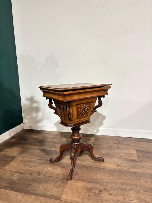 fig 8. A 19th-century Victorian walnut trumpet sewing table with fretwork side panels, a hinged top lid, turned pedestal, and carved tripod cabriole legs.