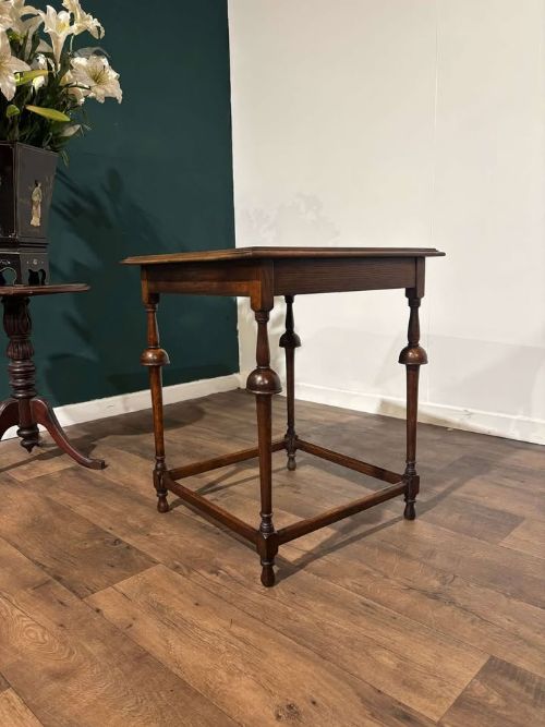 fig 3. A square dark oak window table featuring distinct turned legs with central bulbous knops and a lower perimeter box stretcher.