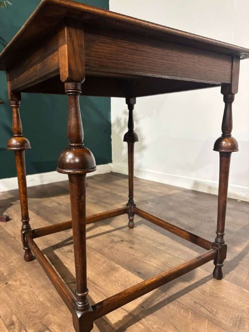 fig 4. A square dark oak window table featuring distinct turned legs with central bulbous knops and a lower perimeter box stretcher.
