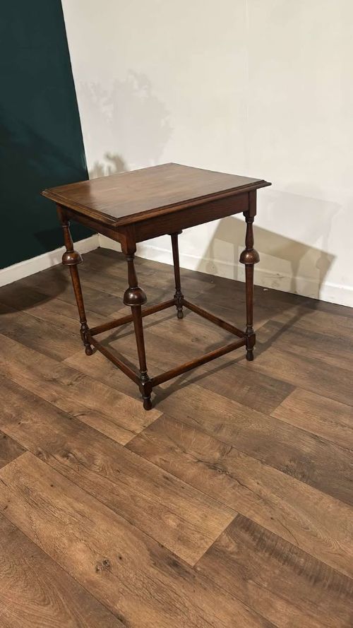 fig 5. A square dark oak window table featuring distinct turned legs with central bulbous knops and a lower perimeter box stretcher.