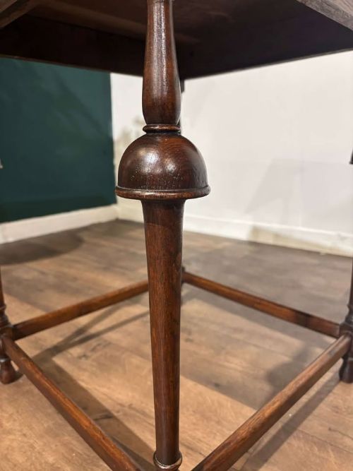 fig 6. A square dark oak window table featuring distinct turned legs with central bulbous knops and a lower perimeter box stretcher.