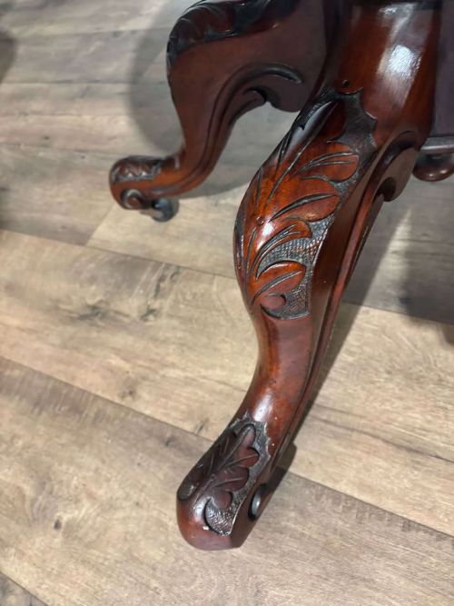 fig 7. An oval Victorian mahogany breakfast table featuring a central turned pedestal and four carved legs with castors.
