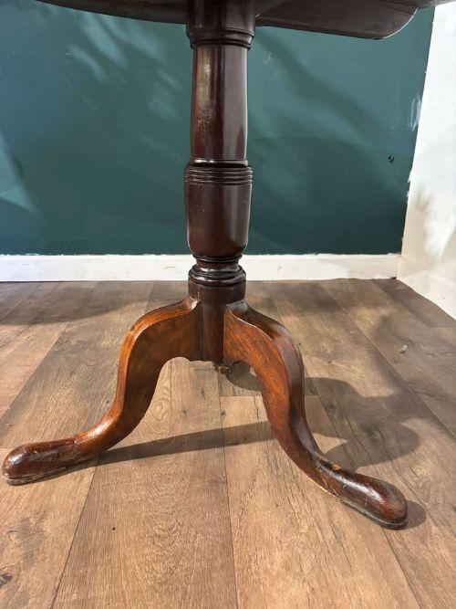 fig 3. A nineteenth-century mahogany tripod table featuring a circular polished top on a turned pedestal column with three splayed cabriole legs.
