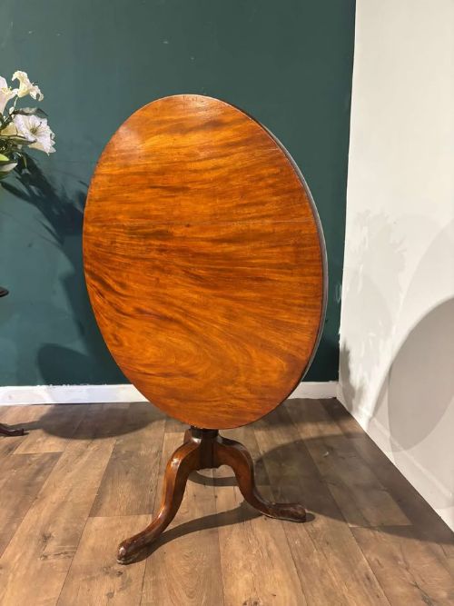 fig 5. A nineteenth-century mahogany tripod table featuring a circular polished top on a turned pedestal column with three splayed cabriole legs.