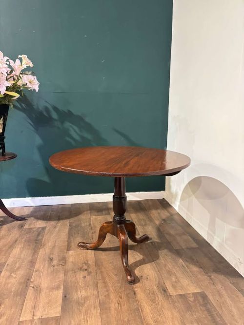 fig 7. A nineteenth-century mahogany tripod table featuring a circular polished top on a turned pedestal column with three splayed cabriole legs.