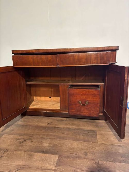 fig 7. A Victorian flame mahogany chiffonier featuring two frieze drawers set over two arched panelled cupboard doors resting on a solid plinth base.
