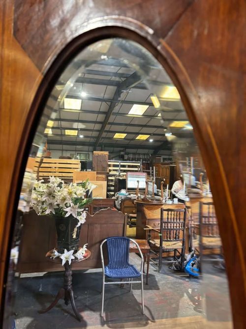 fig 7. An Edwardian walnut double wardrobe featuring two full-length oval mirrored doors flanking an inlaid central panel above a wide base drawer.