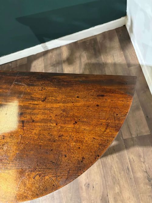 fig 4. A semi-circular antique mahogany D-end table with four square tapered legs and a polished timber top.