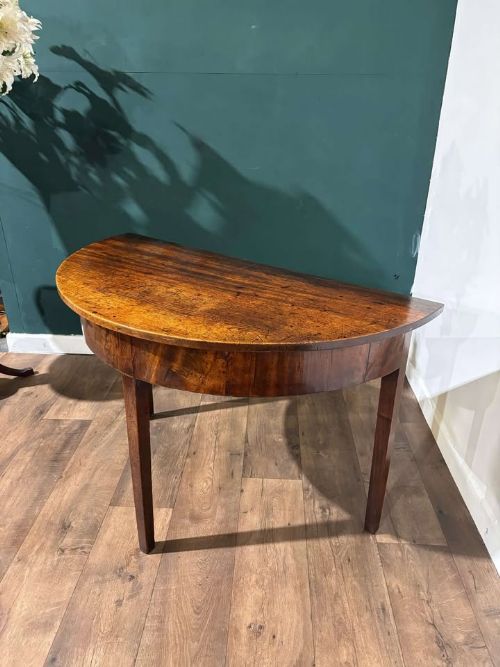 fig 5. A semi-circular antique mahogany D-end table with four square tapered legs and a polished timber top.