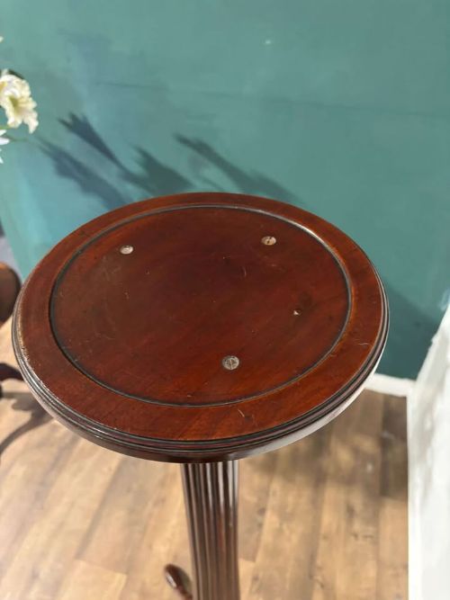 fig 2. A tall mahogany torchere plant stand featuring a circular dished top, a fluted column, and a tripod pedestal base.