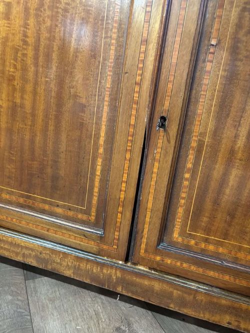 fig 1. An Edwardian inlaid mahogany bureau bookcase featuring upper geometric glazed doors above a slant-front drop-down desk and lower cupboards.