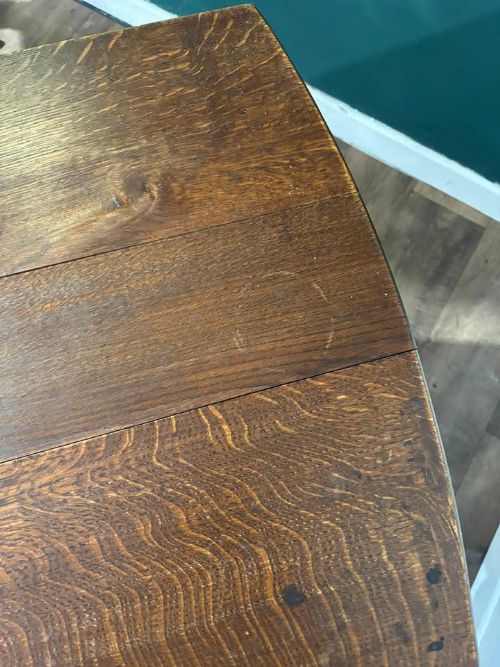 fig 2. A dark oak drop-leaf dining table with an oval top, turned legs, shaped aprons, and perimeter stretchers.