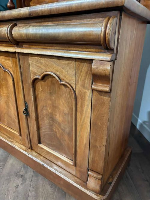 fig 3. A Victorian mahogany chiffonier cabinet featuring a scroll-carved splashback shelf over a two-door cupboard set on a solid plinth base.