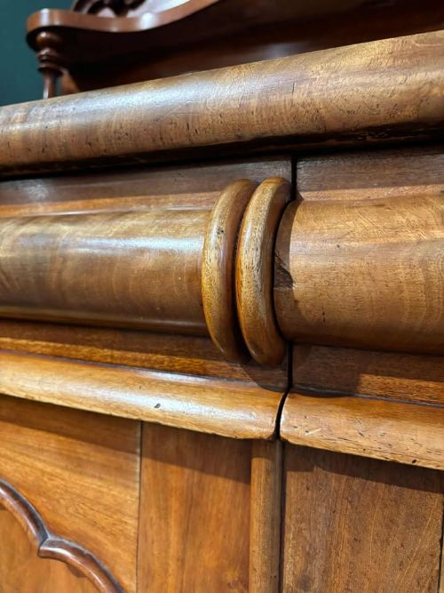 fig 5. A Victorian mahogany chiffonier cabinet featuring a scroll-carved splashback shelf over a two-door cupboard set on a solid plinth base.
