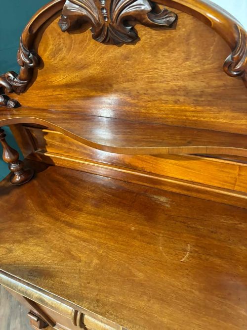 fig 7. A Victorian mahogany chiffonier cabinet featuring a scroll-carved splashback shelf over a two-door cupboard set on a solid plinth base.