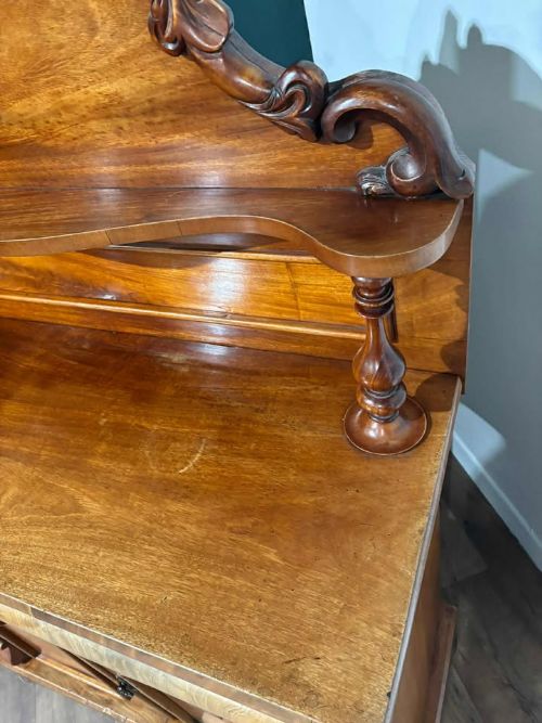 fig 8. A Victorian mahogany chiffonier cabinet featuring a scroll-carved splashback shelf over a two-door cupboard set on a solid plinth base.