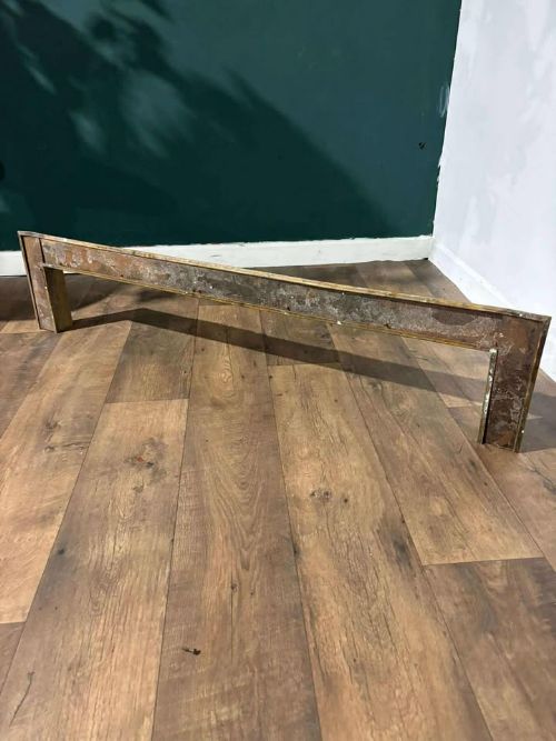 fig 1. An Edwardian brass fireplace fender featuring neoclassical swag decorative motifs on an angled metal frame.