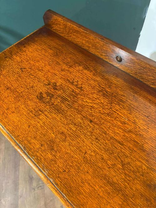 fig 1. A medium brown vintage oak chest of drawers featuring three split-panel drawer fronts, carved frieze detailing, a low back gallery, and barley twist legs connected by stretchers.