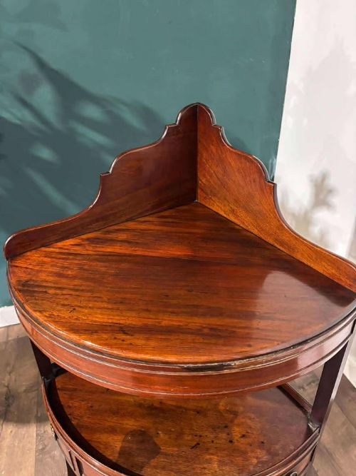 fig 6. A Georgian mahogany corner washstand featuring a tiered design with a shaped splashback, central bowfront drawer, and curved lower stretcher.