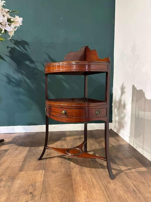 fig 7. A Georgian mahogany corner washstand featuring a tiered design with a shaped splashback, central bowfront drawer, and curved lower stretcher.